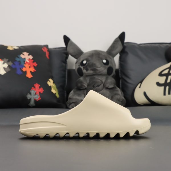Single shoe side view of Yeezy Slide Bone in beige EVA